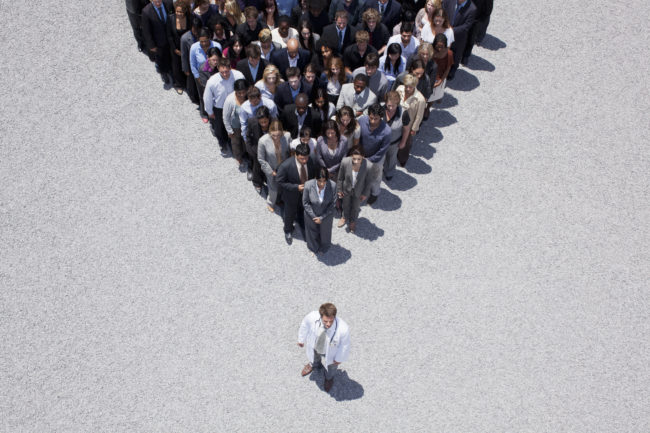 Doctor at apex of pyramid formed by crowd Attractivité des métiers de la santé